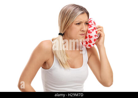 Young woman having a toothache and holding an ice pack isolated on white background Stock Photo
