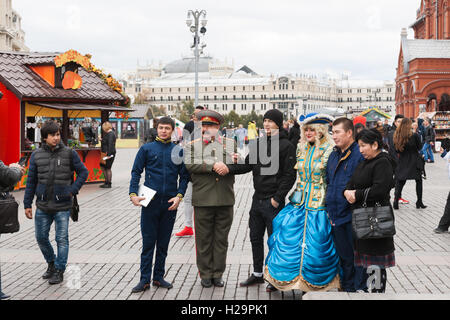 Moscow, Russia, September 25, 2016: Food and crafts fair Golden Autumn is under way in Moscow. A number of markets were opened in the center of the city. People can try and buy food and crafts from many regions of Russia, and CIS, as well as listen to open air concerts and take park in other entertainments. The weather is quiet, warm (+10 Centigrade), but cloudy. Unidentified, tourists take a shot with Stalin and Catherine the Great look-a-likes on decorated Manege square. For editorial use only. Credit:  Alex's Pictures/Alamy Live News Stock Photo