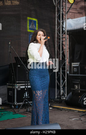 Moscow, Russia, September 25, 2016: Food and crafts fair Golden Autumn is under way in Moscow. A number of markets were opened in the center of the city. People can try and buy food and crafts from many regions of Russia, and CIS, as well as listen to open air concerts and take park in other entertainments. The weather is quiet, warm (+10 Centigrade), but cloudy. Unidentified woman singer sings a song on the street stage. For editorial use only. Credit:  Alex's Pictures/Alamy Live News Stock Photo