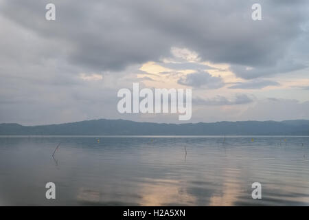Pastel color sky and water at sunset over lake at Lake Bosomtwe in Ghana Stock Photo