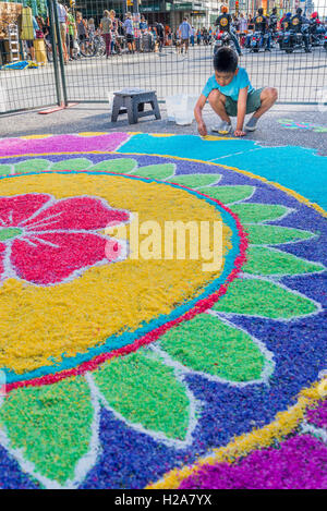 Boy adding rice to large mandala Rangoli floor decoration India Live Street Festival Celebration, Vancouver, British Columbia, Stock Photo