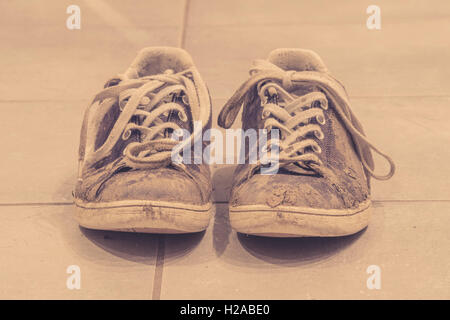 Muddy sneaker shoes with laces in sepia color Stock Photo