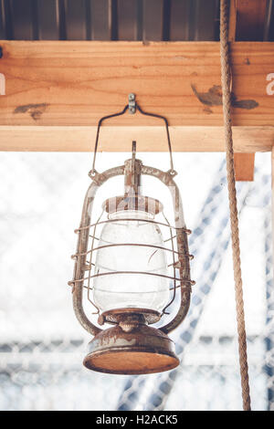 Vintage western lantern hanging on a wooden plank in a barn Stock Photo