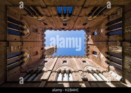 Upwards view of Torre del Mangia from inside Palazzo Pubblico, Siena, Tuscany, Italy Stock Photo
