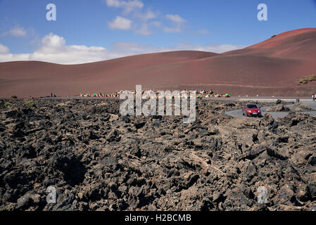 Camel Safari in Lanzarote Canary Islands.View of the tourists, camels and volcanic landscape Stock Photo