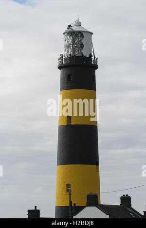 Industrial painting at height, painting contractors painting a lighthouse at St John's Point County Down Northern Ireland. Stock Photo