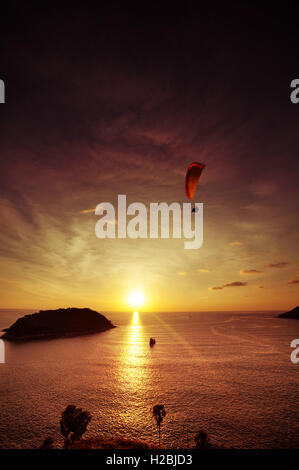 Skydiver flies over the sea on the background of sunset vertical Stock Photo