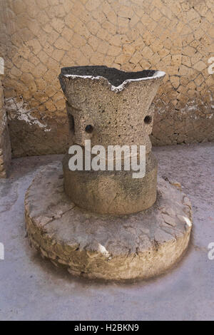 A flour mill (grindstone) in Herculaneum, a Roman port buried during the volcanic eruption of Vesuvius on the 24th August 79 AD Stock Photo