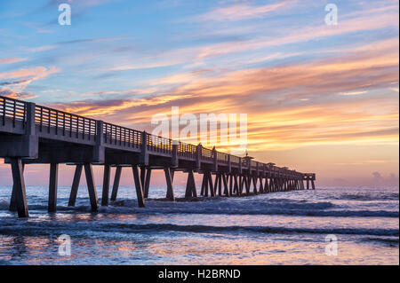 A beautiful sunrise paints the sky and ocean with vivid color at the Jacksonville Beach Pier in Northeast Florida. (USA) Stock Photo