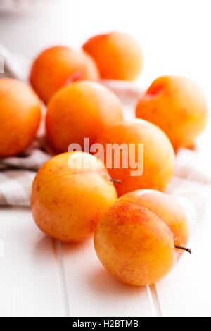 Ripe yellow plums on kitchen table. Stock Photo
