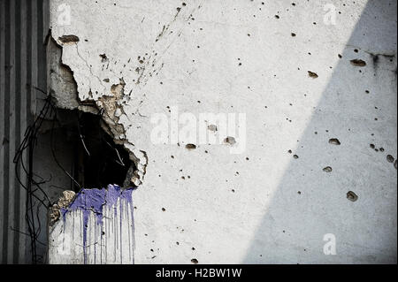 Traces of bullets on a building facade destroyed by war Stock Photo