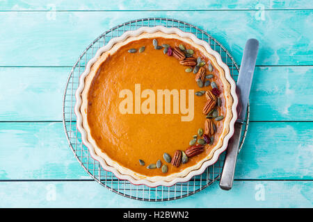 Tasty pumpkin pie, tart made for Thanksgiving day in a baking dish on a cooling rack. Stock Photo