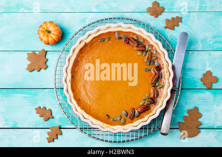 Tasty pumpkin pie, tart made for Thanksgiving day in a baking dish on a cooling rack. Stock Photo