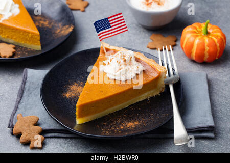 Pumpkin pie, tart made for Thanksgiving day with whipped cream with American flag on top. Stock Photo