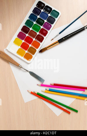 paints and pencils for drawing are around a blank slate Stock Photo