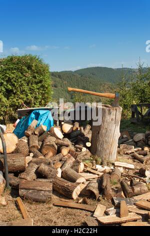 Old ax on log and firewood. Axe Cut into Wood after Chopping Firewood. Stock Photo