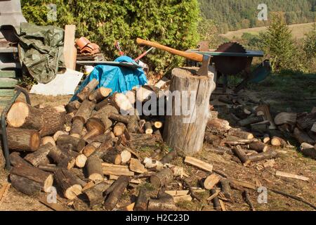 Old ax on log and firewood. Axe Cut into Wood after Chopping Firewood. Stock Photo