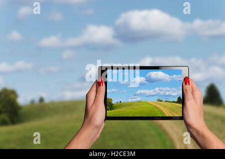 hands holding a tablet taking beautiful photographs of nature improving vision Stock Photo