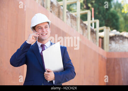 Architect On Building Site Using Mobile Phone Stock Photo