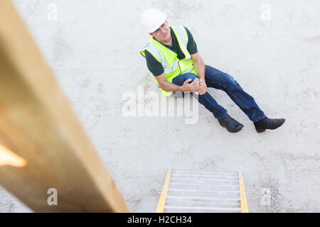 Construction Worker Falling Off Ladder And Injuring Leg Stock Photo