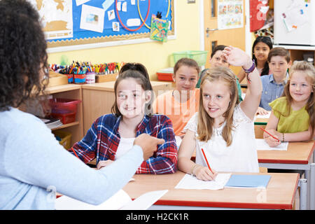 Female Elementary Pupil Answering Question In Class Stock Photo