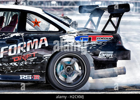 Car drifting auto racing event action with smoking tyres. Pattaya Thailand S. E. Asia Stock Photo
