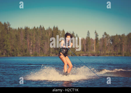 Young pretty woman study riding wakeboard on a lake Stock Photo