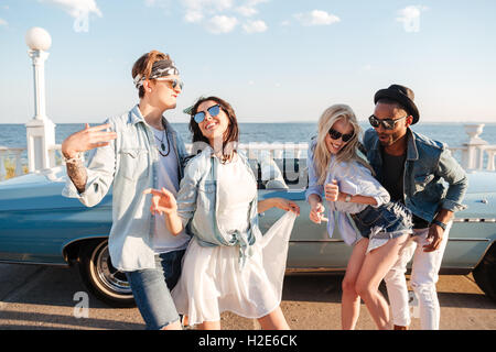 Two cheerful young couples dancing and having fun in summer Stock Photo