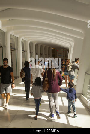 Visitors and shoppers in the Oculus Mall at the World Trade Center walk through one of the corridors overlooking the central hall on one side and shops on the other. New York City. Stock Photo