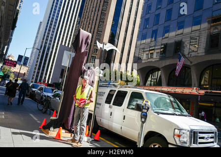 San Francisco, California, USA. 26th September, 2016.  A member of the Carpenters' Local Union 713 wears a reflective vest and stands with an effigy of the grim reaper during a labor protest against Swift Real Estate Partners in the Financial District neighborhood of San Francisco, California. Gado Images/Alamy Live News Stock Photo