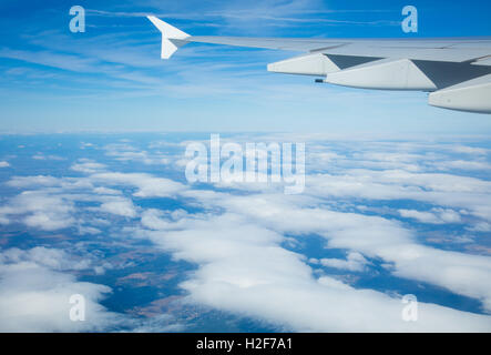 Beautiful view above clouds from airplane perspective with wing Stock Photo