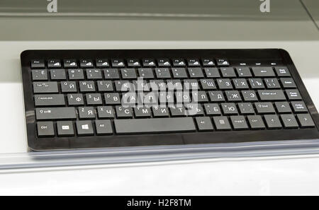Computer keyboard black-grey color on the surface of the table. Stock Photo
