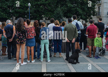 Back view of a group of people and a dog in plaza of Pombo, Santander, Cantabria, Spain, Stock Photo
