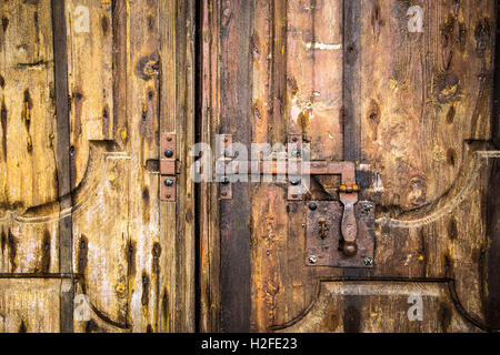 Iron rusty deadbolt on old wooden door. Stock Photo