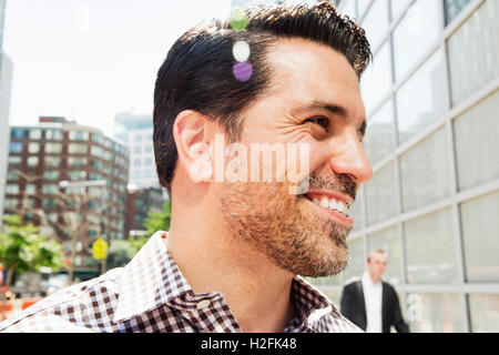 Portrait of a smiling man with brown hair and stubble, wearing a checkered shirt. Stock Photo