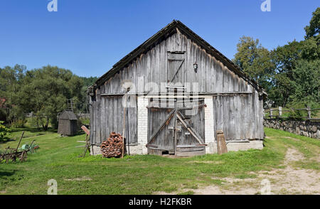 The vintage rural shed at first was a cowshed, later agricultural machinery was stored in him. European poor villages summer lan Stock Photo