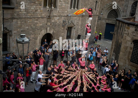 Members of the chinese Colla Xiquets de Hangzhou build a human tower and hold a catalan flag  in Barcelona, Spain. Stock Photo