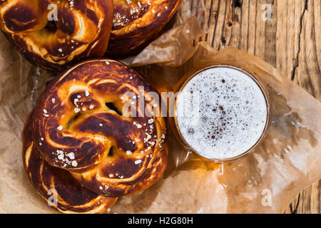 Refreshing beer ready to drink and fresh bavarian pretzels view from top. Traditional food and drink for german Oktoberfest Stock Photo