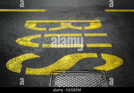 Yellow bus traffic sign painted on asphalt road. Stock Photo