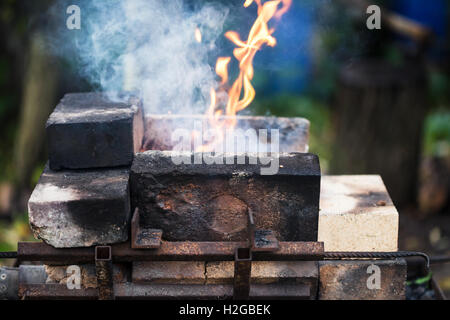flame in outdoor rural brick forging furnace during coal heating Stock Photo