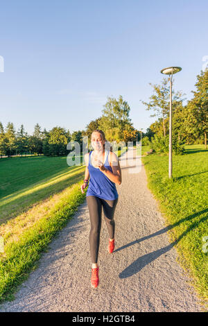 Young woman in sportswear jogging in park, Munich, Upper Bavaria, Bavaria, Germany Stock Photo