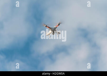Quadcopter, drone with camera flying in front of blue sky, DJI Phantom 3 Stock Photo