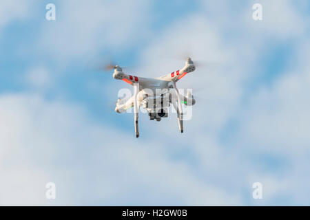 Quadcopter, drone with camera flying in front of blue sky, DJI Phantom 3 Stock Photo