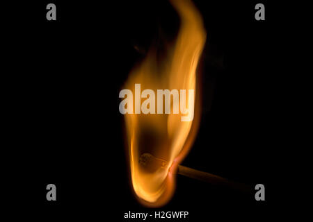 A match being lit isolated against a dark black background Stock Photo