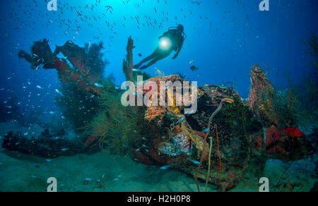 Diver exploring wreck of WW2 Corsair fighter plane aircraft wreck in Pacific Ocean Stock Photo