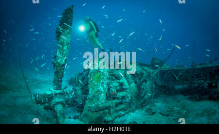 Diver exploring wreck of WW2 Japanese float plane aircraft wreck in Pacific Ocean Stock Photo