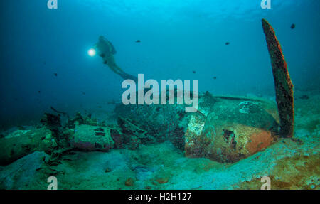 Diver exploring wreck of WW2 Japanese Mitsubishi zero aircraft wreck in Pacific Ocean Stock Photo