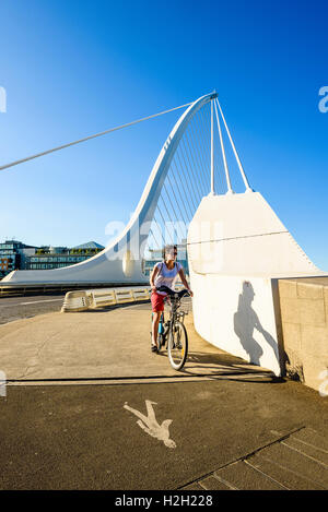 Cyclist at south end of Samuel Beckett Bridge over River Liffey Dublin Ireland