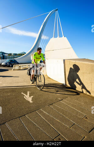 Cyclist at south end of Samuel Beckett Bridge over River Liffey Dublin Ireland