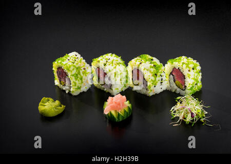 Fresh Uramaki maki Sushi rolls with tuna over black background Stock Photo